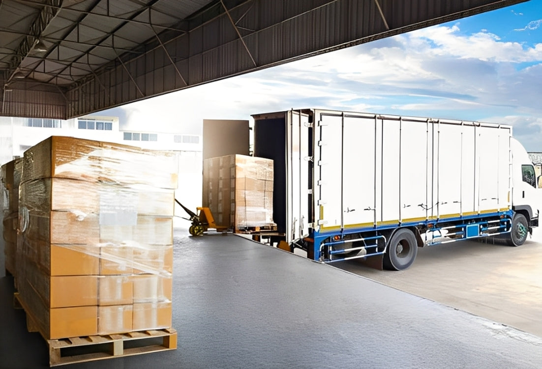 Open warehouse loading dock with pallets and trucks symbolizing fast fulfillment and delivery reliability.